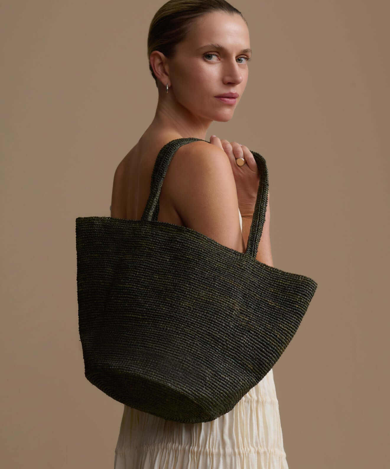 Handbags: Model showcasing a stylish woven handbag against a neutral background.